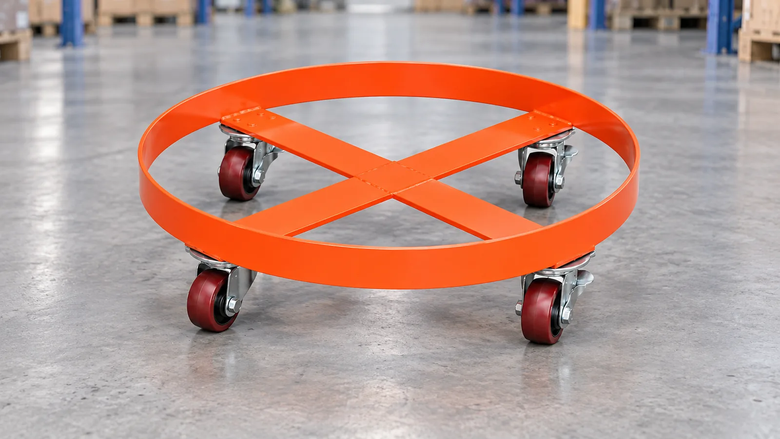 Empty orange round drum dolly with crossed supports and four casters on a warehouse floor